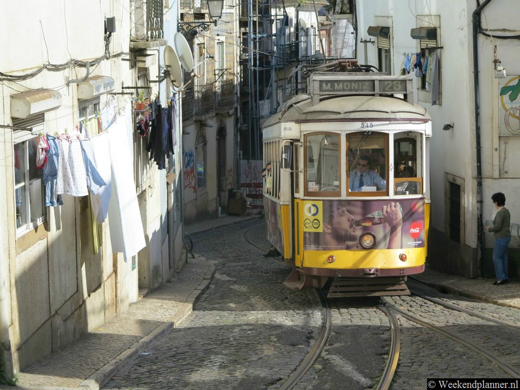 Tram 28 rijdt door de smalle straatjes van Alfama. De trams zijn zo populair bij toeristen dat  ze vaak overvol zijn.Tip: Alfama staat bekend om de muziek in de fadohuizen .